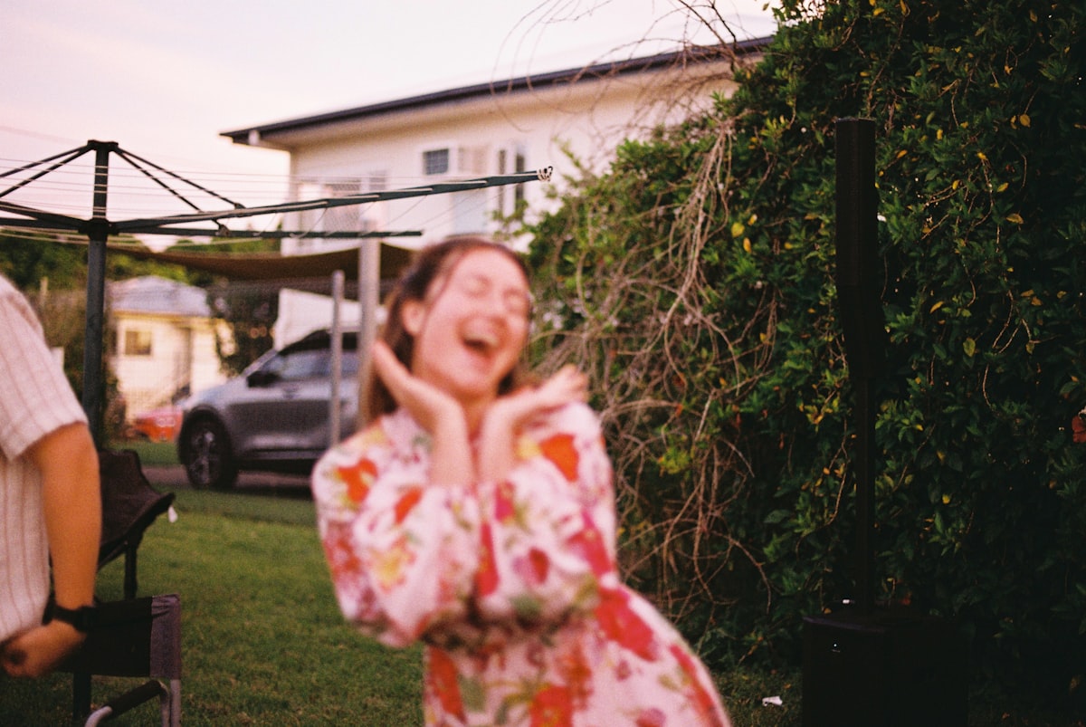 Lachende Frau im Sommerkleid im Garten